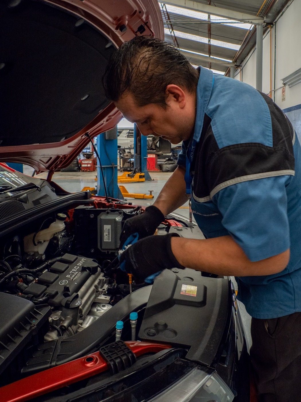 Mecánico de Chevrolet Grupo Félix trabajando en el motor de un vehículo