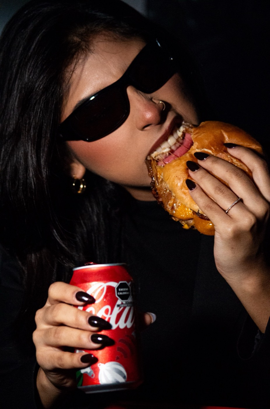 Cliente comiendo hamburguesa de Mordida con Coca-Cola